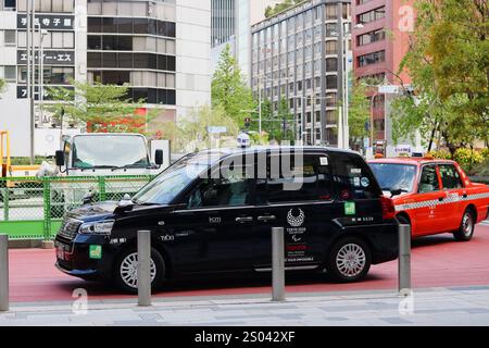 TOKYO, GIAPPONE - 23 aprile 2020: Un paio di taxi nella zona Yaesu di Tokyo di fronte alla stazione di Tokyo. Uno è un taxi Toyota JPN con un Tokyo Paralimpic 2020 Foto Stock