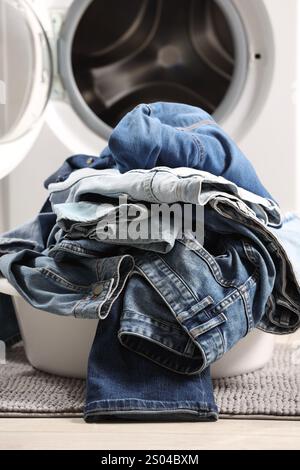 Lavatrice con jeans sporchi e altri indumenti in denim all'interno Foto Stock