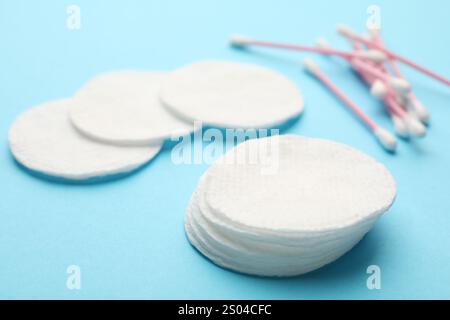 Tamponi e tamponi di cotone su sfondo azzurro, primo piano Foto Stock