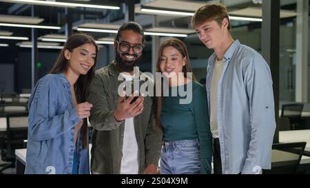 Diverse persone d'affari multirazziali donne uomini studenti gruppo amici guardare schermo cellulare felice allegro sorridente uomini d'affari donne d'affari che utilizzano Foto Stock