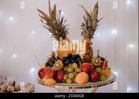 Squisita disposizione di frutta con ananas, uva e prodotti freschi assortiti. Foto Stock