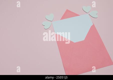 Busta rosa con cuori bianchi su sfondo rosa pastello Foto Stock