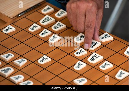I concorrenti si sfidano a vicenda in un gioco da tavolo strategico chiamato shogi, o scacchi giapponesi, in un parco a Tennoji, Osaka, Giappone. Foto Stock