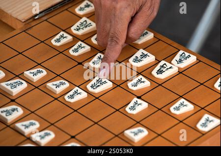 I concorrenti si sfidano a vicenda in un gioco da tavolo strategico chiamato shogi, o scacchi giapponesi, in un parco a Tennoji, Osaka, Giappone. Foto Stock