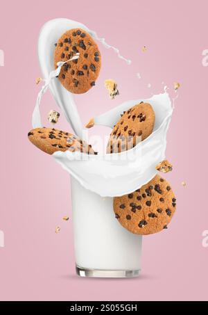 I biscotti con scaglie di cioccolato cadono e si calza con latte spruzzato su sfondo rosa Foto Stock