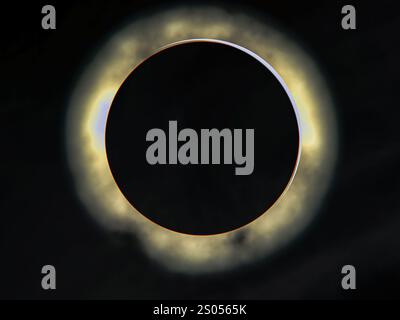 Un'eclissi totale ipnotizzante, con la luna che copre completamente il sole, creando una corona radiosa che si illumina contro il cielo oscuro. Foto Stock