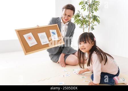 Bambini che prendono lezioni da un insegnante madrelingua in una classe di lingua inglese Foto Stock