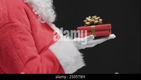 Babbo Natale ha una confezione regalo con spazio per le copie. L'immagine cattura lo spirito del Natale con un'attenzione particolare al regalo. Foto Stock