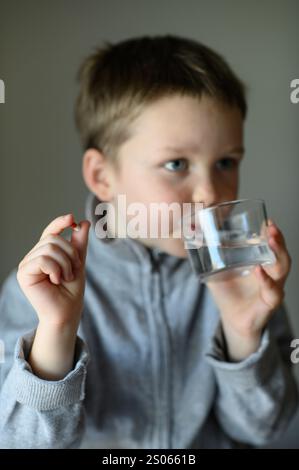 il ragazzo prenderà una pillola di supplemento Foto Stock