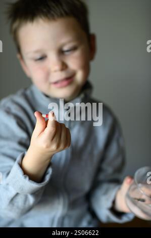 il ragazzo prenderà una pillola di supplemento Foto Stock