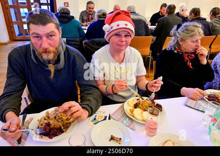 Praga, Repubblica Ceca. 25 dicembre 2024. Il pranzo di Natale per le persone ai margini della società, organizzato dalla comunità di Sant'Egidio, si è tenuto nel Palazzo dell'Arcivescovo di Praga, Repubblica Ceca, il 25 dicembre 2024. Crediti: Vit Simanek/CTK Photo/Alamy Live News Foto Stock