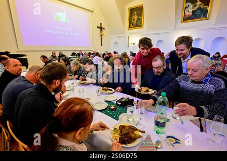 Praga, Repubblica Ceca. 25 dicembre 2024. Il pranzo di Natale per le persone ai margini della società, organizzato dalla comunità di Sant'Egidio, si è tenuto nel Palazzo dell'Arcivescovo di Praga, Repubblica Ceca, il 25 dicembre 2024. Crediti: Vit Simanek/CTK Photo/Alamy Live News Foto Stock