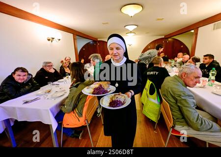 Praga, Repubblica Ceca. 25 dicembre 2024. Il pranzo di Natale per le persone ai margini della società, organizzato dalla comunità di Sant'Egidio, si è tenuto nel Palazzo dell'Arcivescovo di Praga, Repubblica Ceca, il 25 dicembre 2024. Crediti: Vit Simanek/CTK Photo/Alamy Live News Foto Stock