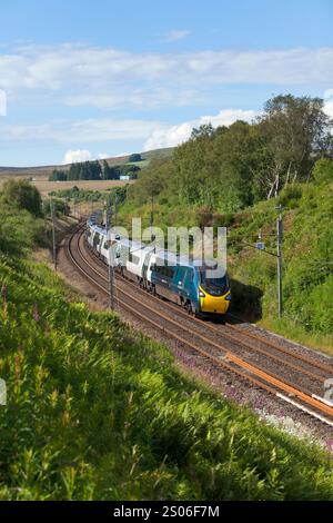 Primo treno Trenitalia Avant West Coast Alstom Pendolino 390118 che scende dalla riva di Shap sulla linea principale della costa occidentale in Cumbria a Greenholme Foto Stock