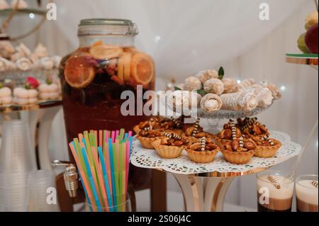 Squisita esposizione da tavolo di dessert con prelibatezze colorate e bevande rinfrescanti. Foto Stock