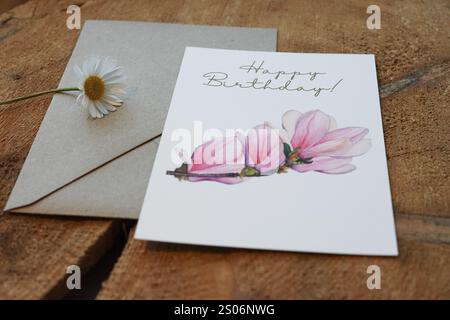 Biglietto di auguri di buon compleanno con un ramo di magnolia dipinto ad acquerello, con busta di carta kraft, biglietto come foto di prodotto in vendita su Etsy, decorato su Foto Stock