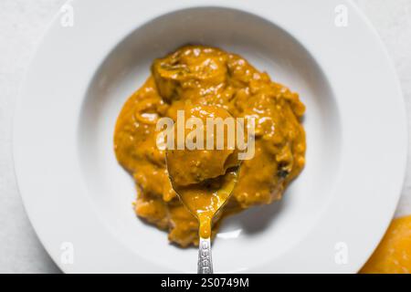 Vista dall'alto della zuppa nigeriana di owo con pesce e manzo in un piatto bianco, vista dall'alto della zuppa di oghwo in un ampio piatto da pranzo Foto Stock