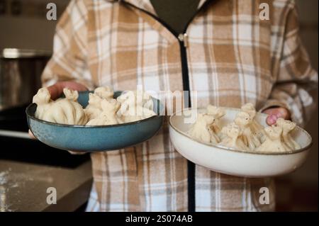 Khinkali georgiano fatti in casa servito in ciotole, preparato fresco in una cucina calda e invitante. Foto Stock