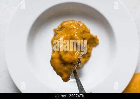 Vista dall'alto della zuppa nigeriana di owo con pesce e manzo in un piatto bianco, vista dall'alto della zuppa di oghwo in un ampio piatto da pranzo Foto Stock