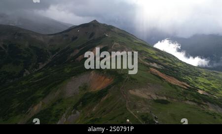 Splendida vista aerea di un paesaggio montano mozzafiato circondato da maestose nuvole Foto Stock