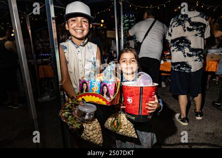 Buenos Aires, Argentina. 24 dicembre 2024. I bambini sorridono alla macchina fotografica mentre tengono in mano i loro pacchetti di dolci e cibo. La cena della vigilia di Natale di fronte al Congresso Nazionale è stata organizzata dal gruppo Argentina Humana e dal movimento dei lavoratori esclusi (MTE) che è composto da centinaia di persone che si guadagnano da vivere riciclando rifiuti. Lo slogan era "Nessuna famiglia senza Natale”. Credito: SOPA Images Limited/Alamy Live News Foto Stock