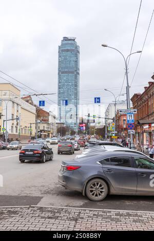 Ekaterinburg, Russia - 26 ottobre 2024: Vista verticale sulla strada con il grattacielo Vysotsky, persone e auto sono sulla strada Foto Stock