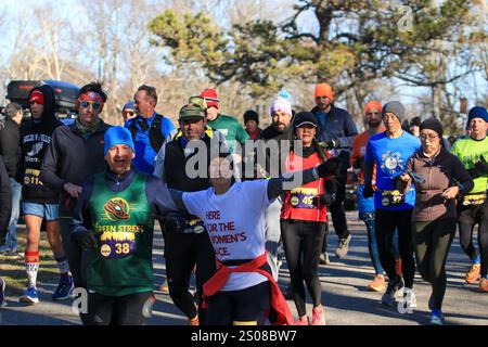 Smithtown, New York, Stati Uniti d'America - 14 dicembre 2024: I corridori con attrezzatura colorata corrono in un parco, abbracciando il freddo e godendosi l'evento della comunità. Foto Stock