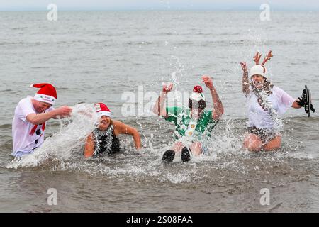 Ayr, Regno Unito. 26 dicembre 2024. Diverse centinaia di nuotatori hanno preso parte all'annuale Boxing Day Charity DIP raccogliendo fondi per sostenere l'Ayrshire Cancer Support nuotando nel Firth of Clyde al largo di South Beach, Ayr, Ayrshire, Scozia, Regno Unito. Questo popolare evento benefico ha raccolto 25.000 sterline l'anno scorso e l'obiettivo di quest'anno è di 30 000 sterline. Crediti: Findlay/Alamy Live News Foto Stock