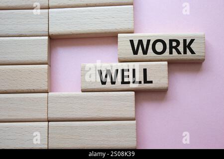 Simbolo di lavoro. La parola concettuale funziona bene sui blocchi di legno. Bellissimo sfondo rosa. Concetto di lavoro e lavoro bene. Copia spazio Foto Stock