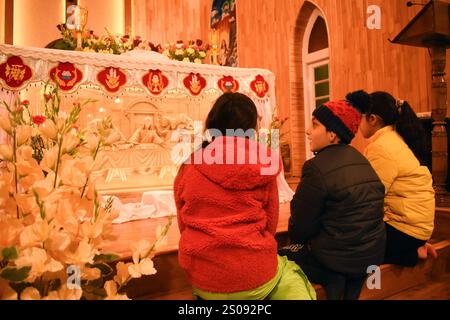 I bambini cristiani offrono preghiere all'interno della Chiesa cattolica della Sacra famiglia come parte delle celebrazioni natalizie a Srinagar, Jammu e Kashmir, il 25 dicembre 2024. (Foto di Danish Showkat/ Sipa USA) Foto Stock