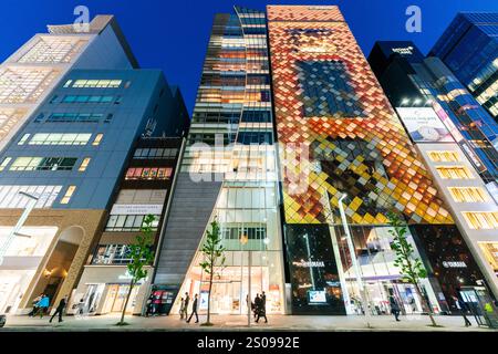 Ampio angolo basso dall'altra parte della strada vista della facciata illuminata di Beauty Connection e degli edifici Yamaha sulla Ginza di notte. Foto Stock