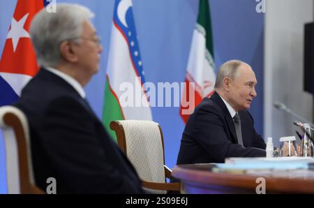 Orekhovo, Russia. 26 dicembre 2024. Il presidente russo Vladimir Putin, a destra, ospita il vertice dei leader del Consiglio economico eurasiatico mentre il presidente kazako Kassym-Jomart Tokayev, a sinistra, guarda al resort di Igora, il 26 dicembre 2024, a Orekhovo, nell'Oblast di Leningrado, in Russia. Crediti: Gavriil Grigorov/piscina del Cremlino/Alamy Live News Foto Stock