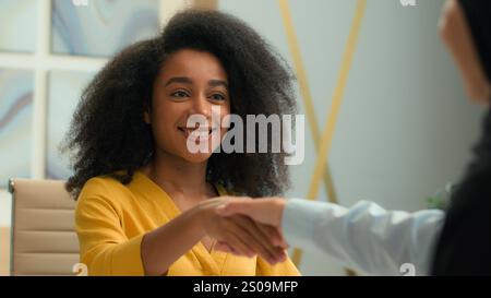 Ragazza afroamericana donna d'affari felice datore di lavoro assunzione di risorse umane candidato concludere accordo accordo stringere la mano a partner commerciali donne Foto Stock