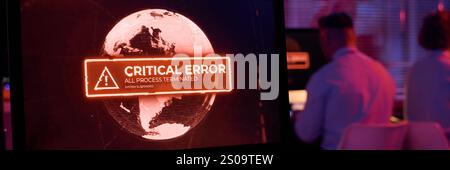 Intestazione del luogo di lavoro del tecnico IT in una sala server buia con schermo del computer che mostra un errore critico nel processo di lavoro Foto Stock