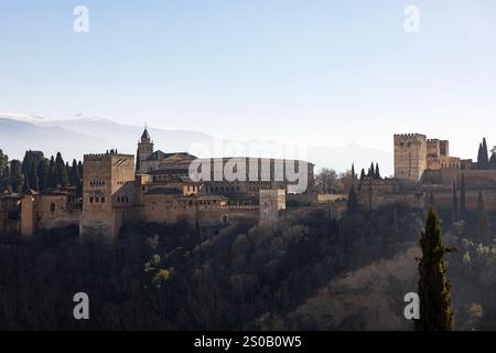 La fortezza e il complesso del palazzo dell'Alhambra si trovano in cima a una collina sotto i cieli nebbiosi di Granada, Spagna. Foto Stock