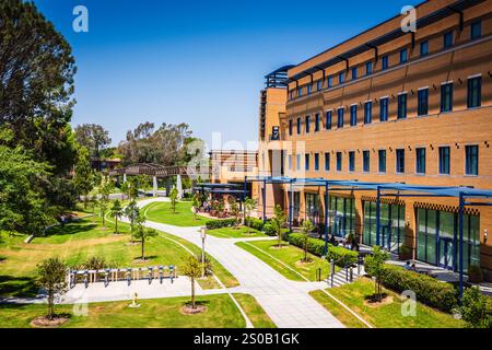 Irvine CA USA - 10 agosto 2017: Passerella, prato e portabiciclette presso l'Università della California presso il campus di Irvine (UCI). Foto Stock