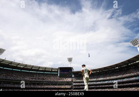 MELBOURNE, AUSTRALIA. 27 dicembre 2024. Scott Boland dell'Australia, giorno 2 quarto test in un'ampia immagine del Melbourne Cricket Ground con spettatori pieni alle spalle e un cielo estivo, scattato durante il test Cricket Australia vs India al Melbourne Cricket Ground, Melbourne, Australia il 27 dicembre 2024. Crediti: Karl Phillipson/Alamy Live News Foto Stock