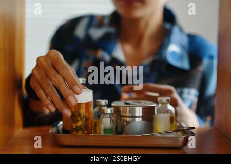 Donna irriconoscibile che fa fuori Jar of Pills Foto Stock