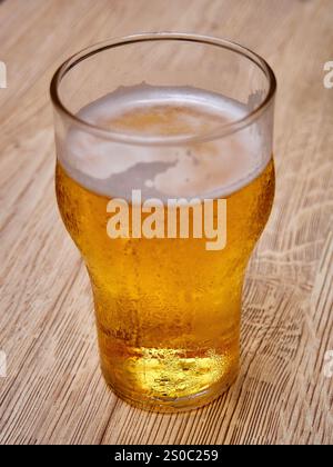 Bicchiere di birra su fondo di legno. Birra in un bicchiere. Foto Stock