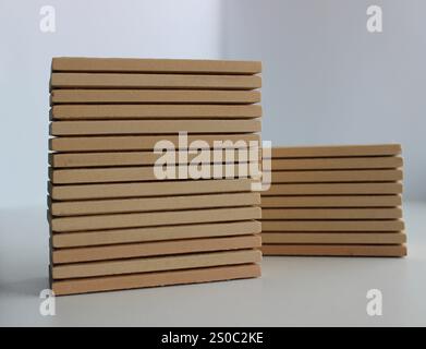 Due pallet di piastrelle in ceramica beige isolati su foto di scorta bianca. Diverse altezze pile di piastrelle a parete con superficie di pietre artificiali Foto Stock