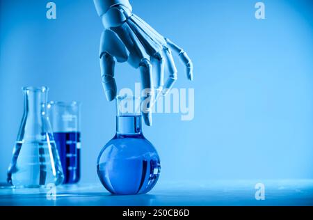 Intelligenza artificiale. Mano robot con fiasca al tavolo in luce blu, spazio per testo Foto Stock