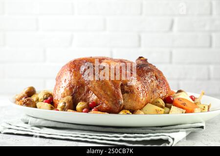 Delizioso tacchino al forno, verdure e mirtilli rossi su un tavolo testurizzato grigio contro il primo piano della parete di mattoni bianchi Foto Stock