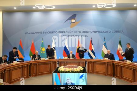 Orekhovo, Russia. 26 dicembre 2024. Il presidente russo Vladimir Putin, centro, firma accordi con i leader regionali alla conclusione del vertice del Consiglio economico eurasiatico del 26 dicembre 2024 a Orechovo, Oblast di Leningrado, Russia. Seduta da sinistra: Il presidente kirghiso Sadyr Japarov, il presidente kazako Kassym-Jomart Tokayev, il presidente russo Vladimir Putin e il presidente bielorusso Alexander Lukashenko. Crediti: Gavriil Grigorov/piscina del Cremlino/Alamy Live News Foto Stock