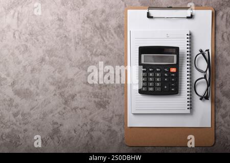 Concetto di contabilità sul luogo di lavoro. Vista dall'alto, accessori per ufficio, penna calcolatrice, appunti, blocco appunti isolato su sfondo grigio scuro con spazio vuoto Foto Stock