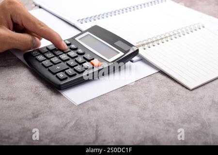 Uomo d'affari con calcolatrice. Calcolo delle finanze delle famiglie e degli appunti di scrittura, contabilità aziendale, gestione del budget. Finanza, budget e tasse c Foto Stock