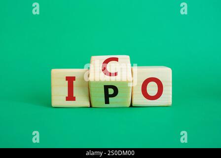 Simbolo ICO e IPO. Cubi di legno con parole ICO - offerta iniziale di monete e IPO - offerta pubblica iniziale. Bellissimo sfondo verde. Business concep Foto Stock