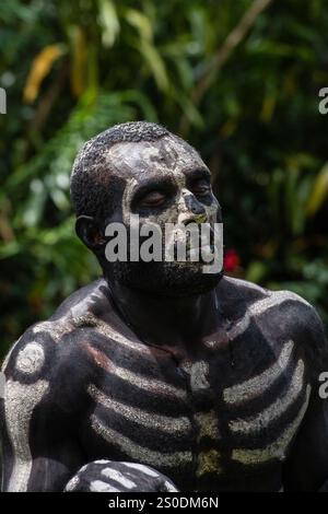 Gli Skeleton Men della tribù Omo Bugamo della Papua nuova Guinea dipingono i loro corpi con vernice bianca e nera che emula lo scheletro umano, Chimbu Prov Foto Stock