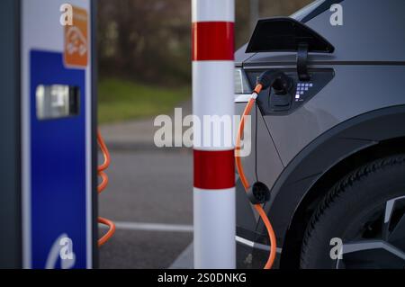 E-Vehicle Hyundai IONIQ 5 presso la stazione di ricarica EnBW per auto elettriche, stazione di ricarica, stazione di ricarica elettrica, mobilità elettrica, cavo di ricarica per l'e-car Foto Stock