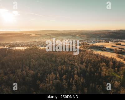 Vista aerea di un piccolo villaggio circondato da foreste e campi al tramonto, Gechingen, regione di Heckengaeu, distretto di Calw, Germania, Europa Foto Stock