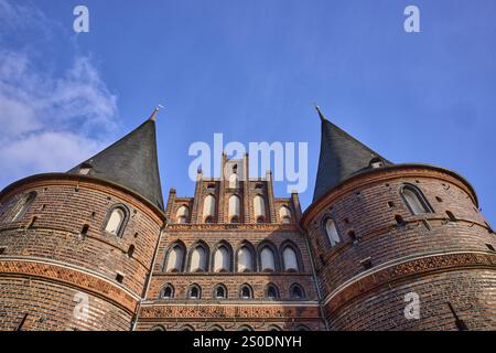 Porta della città, storico edificio in mattoni, torri rotonde con tetto in ardesia, timpano, prospettiva rana, città anseatica di Lubecca, città indipendente, Schleswig-Hols Foto Stock